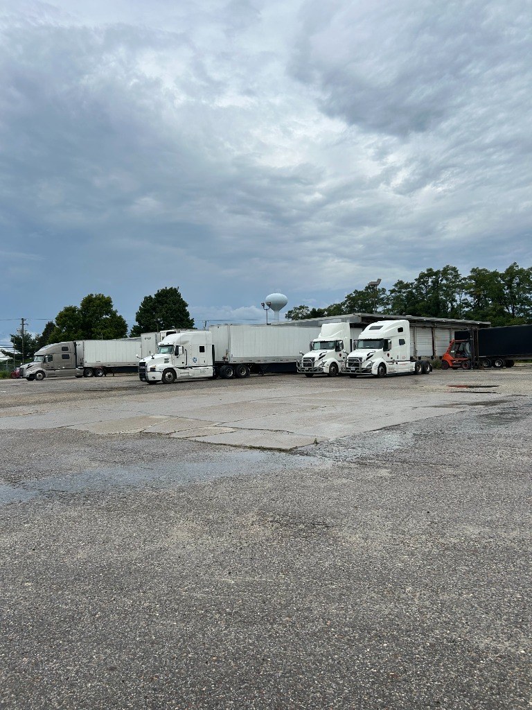 Commercial tractor-trailers staged in paved industrial lot